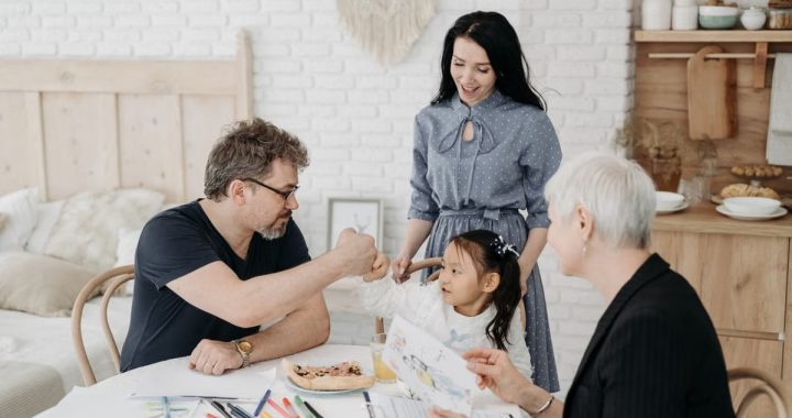 Child with foster parents and a social worker discussing adoption at home.