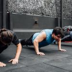 Men performing push-ups during a group workout session in Mexico City gym.